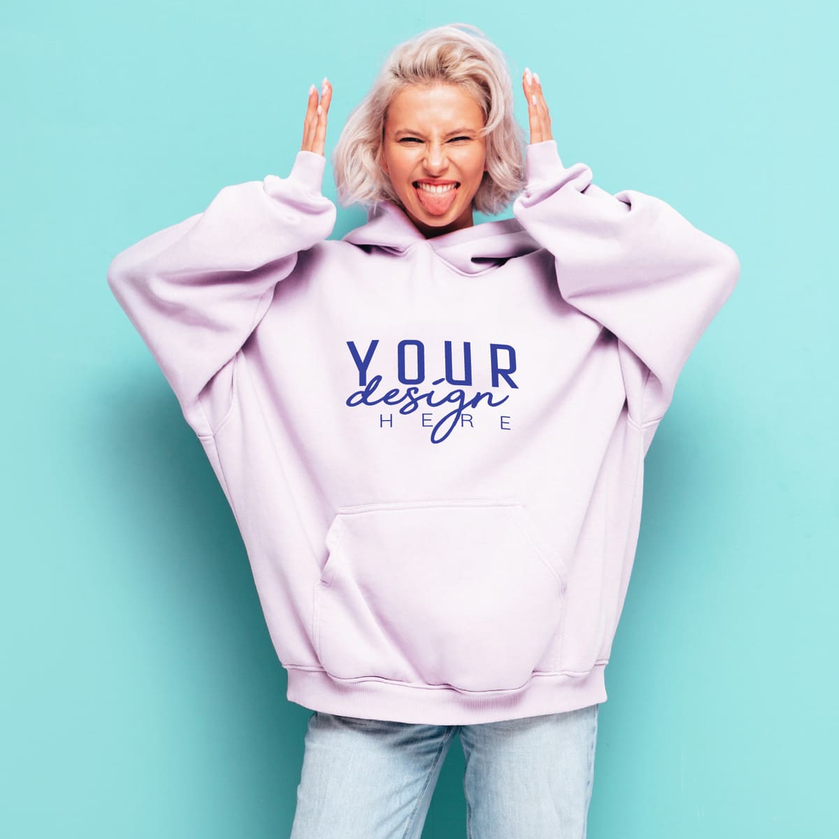 Woman wearing an oversized light purple custom hoodie with blue logo design on a turquoise background
